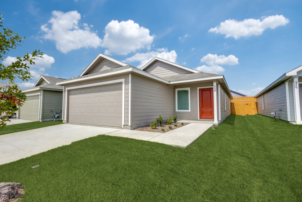 Front exterior view of a modern single-story rental home with a red front door and two-car garage in Princeton, Texas