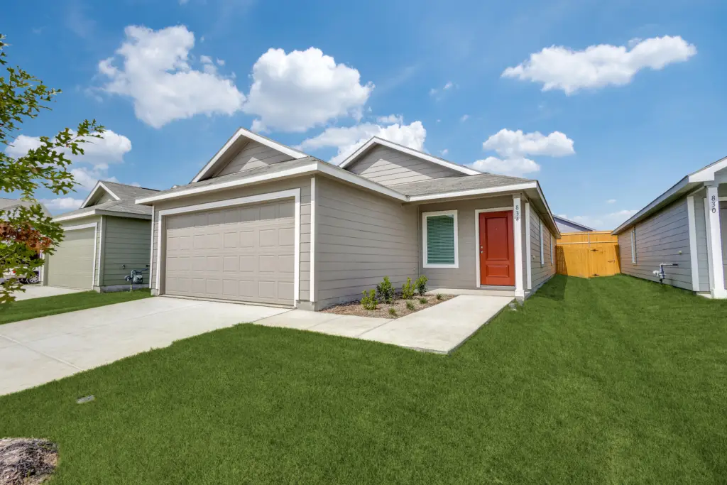 Front exterior view of a modern single-story rental home with a red front door and two-car garage in Princeton, Texas
